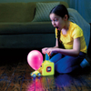 Egy gyerek ámulva figyeli, ahogy a Balloon Zoom felfújja a lufit a kisautóra.