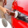 Kézi kefe fehér fejjel polírozza egy piros autó fényszóróját, lent pótpárna.