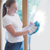 Egy nő a Livington SteamTouch kézi gőztisztítóval tisztítja az ablakot forró gőzzel.