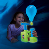 Egy lány játszik a sötétben a Balloon Zoom-mal, a lufi világít.